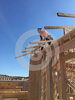 Construction worker working on the framing process for a new a house.