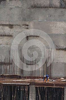 A construction worker working on the roof supported by bars