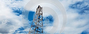 Construction worker working on scaffolding with ladder on building site and beautiful cloud, sky background