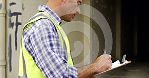 Construction worker writing on a clipboard