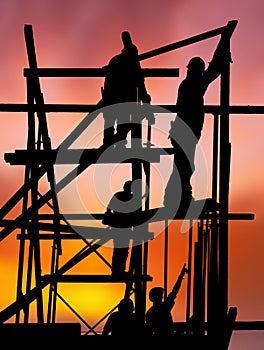 Construction workers against colorful sunset