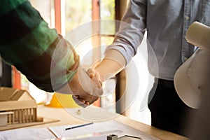 Construction workers, architects and engineers shake hands while working for teamwork and cooperation after completing an