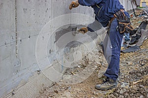 Construction workers with brush applied hydro insulation