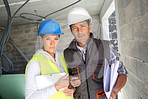 Construction workers on building site with tablet