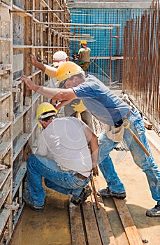 Construction workers busy with formwork frames photo