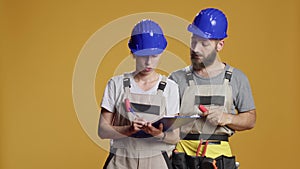 Construction workers calculating measurement on papers