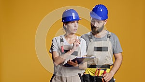 Construction workers calculating measurement on papers