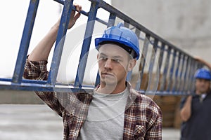 Construction Workers Carrying Ladder