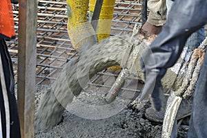 Construction Workers casting concrete using concrete hose