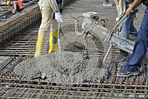 Construction Workers casting concrete using concrete hose