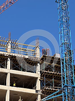 Construction workers collaborating on building site with crane and scaffolding