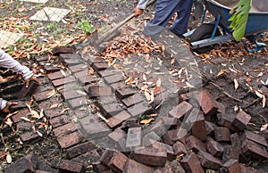 Construction workers digging up bricks