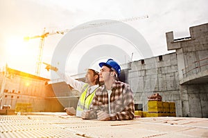 Construction workers discussing job at building site