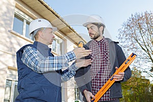 Construction workers in discussion in yard