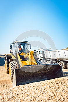 Construction workers doing earthworks with wheel loader photo