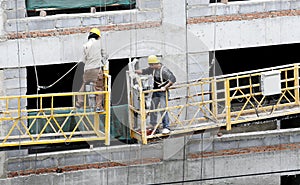 Construction workers on elevator.