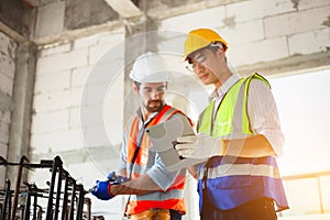 Construction workers and engineers discuss work on a construction site. Safety concept
