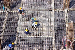 Construction workers fabricating large steel bar reinforcement bar at the in construction area building site