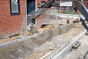 Construction workers finishing construction of new residential house and installing footpath