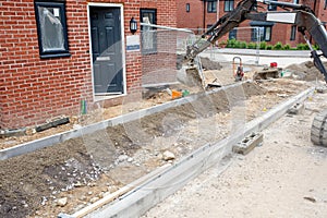 Construction workers finishing construction of new residential house and installing footpath