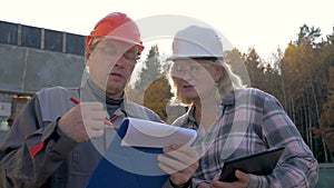 Construction Workers In Helmet Discuss Construction According To Plan Project