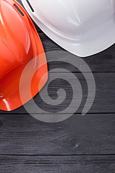 Construction workers helmets on dark wood.