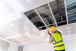 Construction workers are installing the ceiling house in the building under construction, Ceiling installation ideas