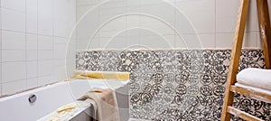 Workers installing modern ceramic tiles on bathroom wall