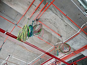 Construction workers installing electrical conduit and cable tray made from metal.