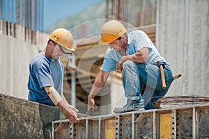 Construction workers installing formwork frames