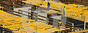 Construction workers installing mounting horizontal formwork on