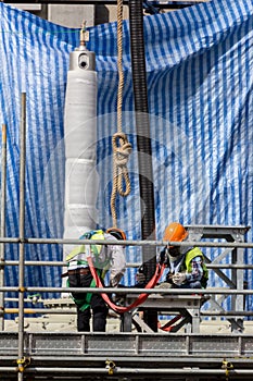 Construction workers installing pipeline on the construction sit.