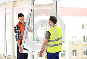 Construction workers installing plastic window