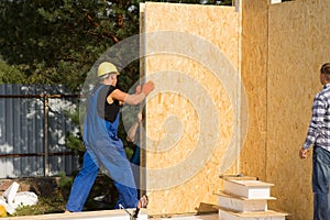 Construction workers installing prefab walls