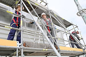 Construction workers installing scaffolding photo