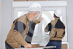 Construction workers installing window in house