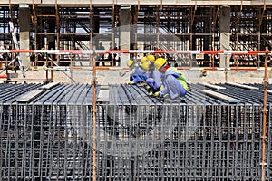 Construction workers knitting rebars
