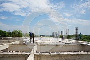 Construction workers lay prestressed concrete flooring on high-rise buildings.