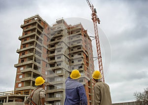 Construction workers observe and inspect the building