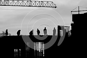 Silhouette of construction workers outdoors at sunset