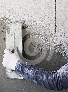 Construction workers plaster the facade of the house.