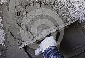 Construction workers plaster the facade of the house. Worker plastering tool plaster