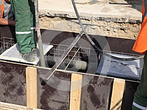 Construction workers are pooring concrete to formwork