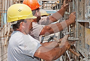 Construction workers positioning formwork frames photo