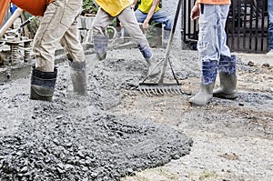 Construction workers pouring cement on road