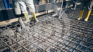 Construction workers are pouring concrete to formwork