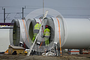Construction workers preparing the rotor blades of a new wind turbine