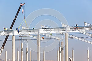 Construction Workers Rigging High Beams Columns