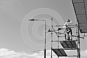 Construction workers on a scaffold. Black and white.
