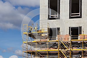 Construction workers on scaffolding - building facade constructi